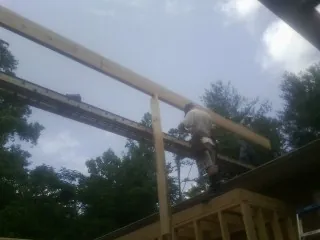 Carpenter setting a ridge beam over a new addition frame — Ice Dam Removal by Roofing Brothers in Barwick