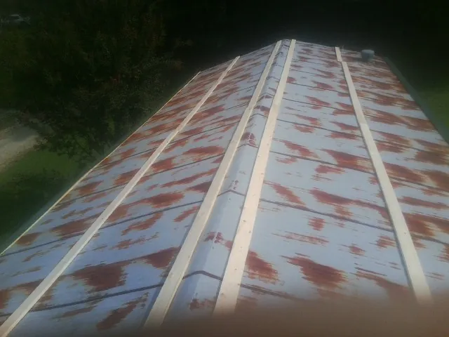 Rusted metal roof panels with new wood purlins before replacement — Storm Damage Roof Repair in Barwick by Roofing Brothers