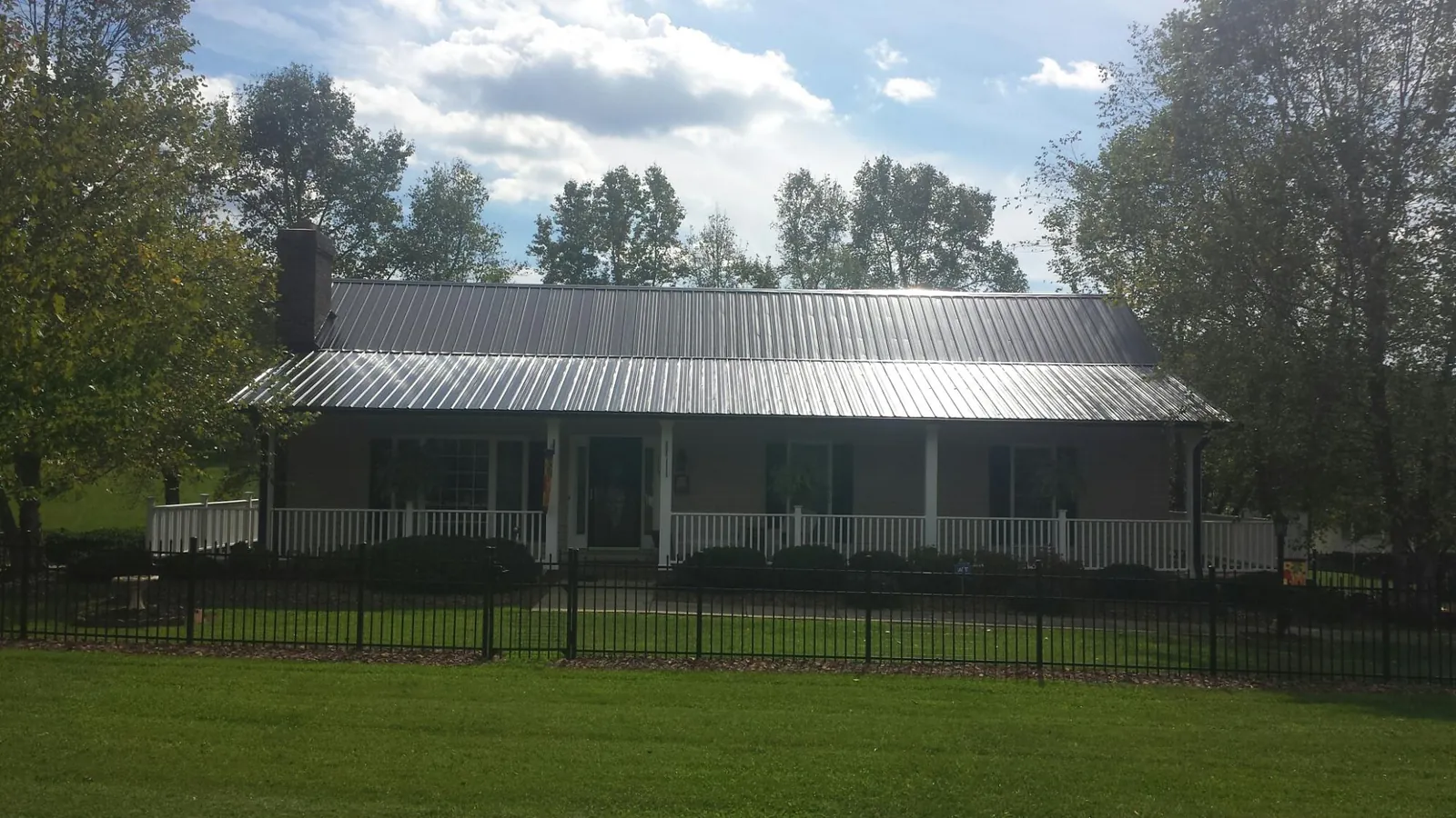 Gray metal roof on a brick ranch with a full width front porch — Gutter Guard Installation work by our crew in Barwick