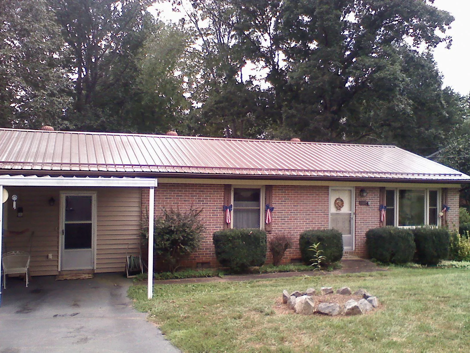 Bronze metal roof and carport on a brick ranch home — Roof Repair work by our crew in Barwick